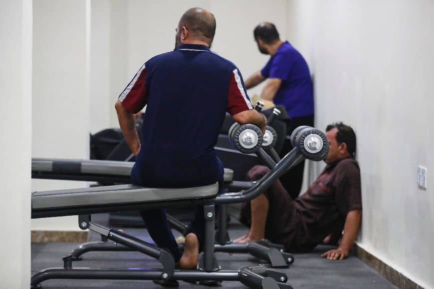 وفي الأجواء الهادئة في صالة الألعاب الرياضية الموجودة بمركز إعادة التأهيل، كان الرجال من جميع الأعمار تقريبًا يلعبون تنس الطاولة وكرة القدم ، وبعضهم يبتسم. كان الآخرون متعبين بشكل واضح أو كانت لديهم تعابير فارغة على وجوههم.