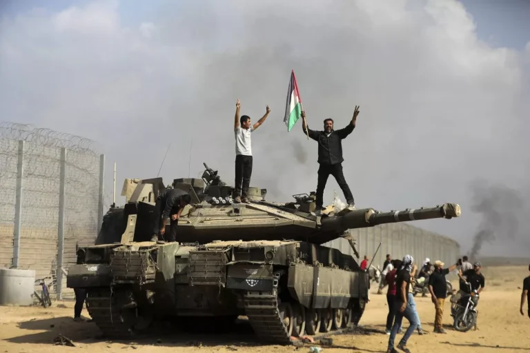افتتاحية وطن: أيها العرب بدأت ساعة الصفر فإما أن تكونوا أو لا تكونوا! فلسطينيون يحتفلون فوق وحول دبابة إسرائيلية مدمرة قرب سياج قطاع غزة شرق خان يونس