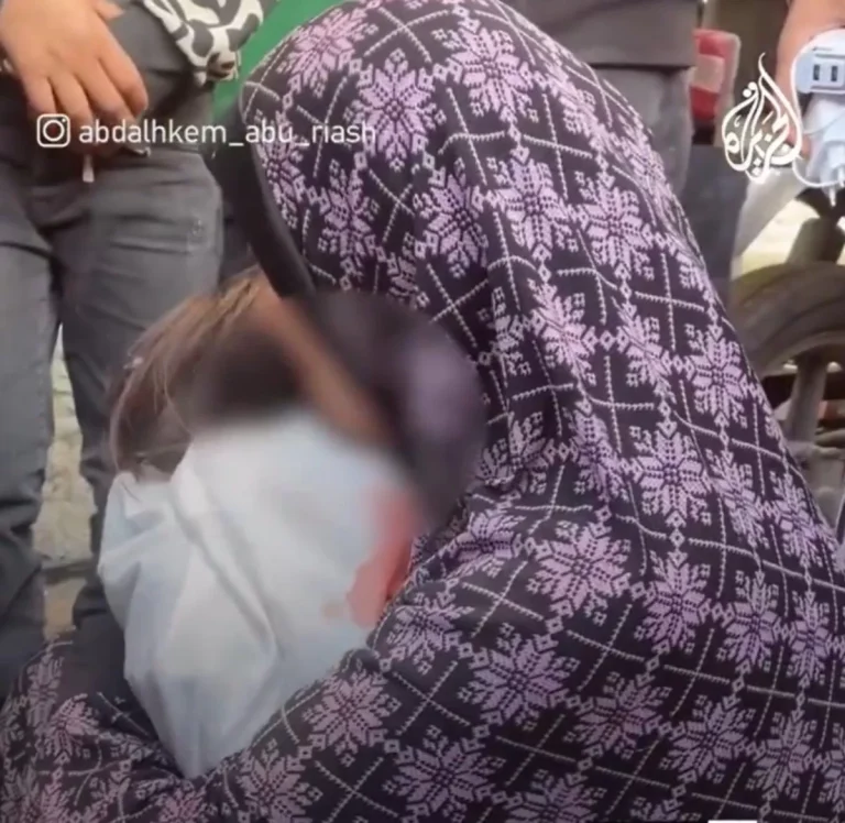 شاهد ما فعلته فلسطينية كاد قلبها ينفطر من البكاء بجثة طفلتها الشهيدة أم فلسطينية تودع ابنتها
